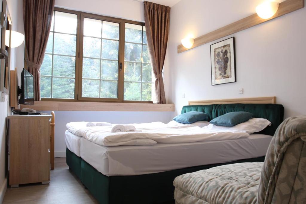 a bedroom with a large bed and a window at Hotel Fersped in Mavrovo