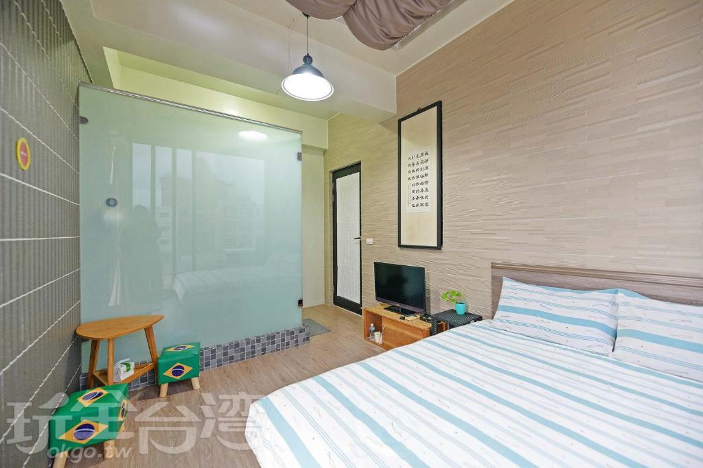 a bedroom with a large bed and a television at Penghu 123 V-Stone in Magong
