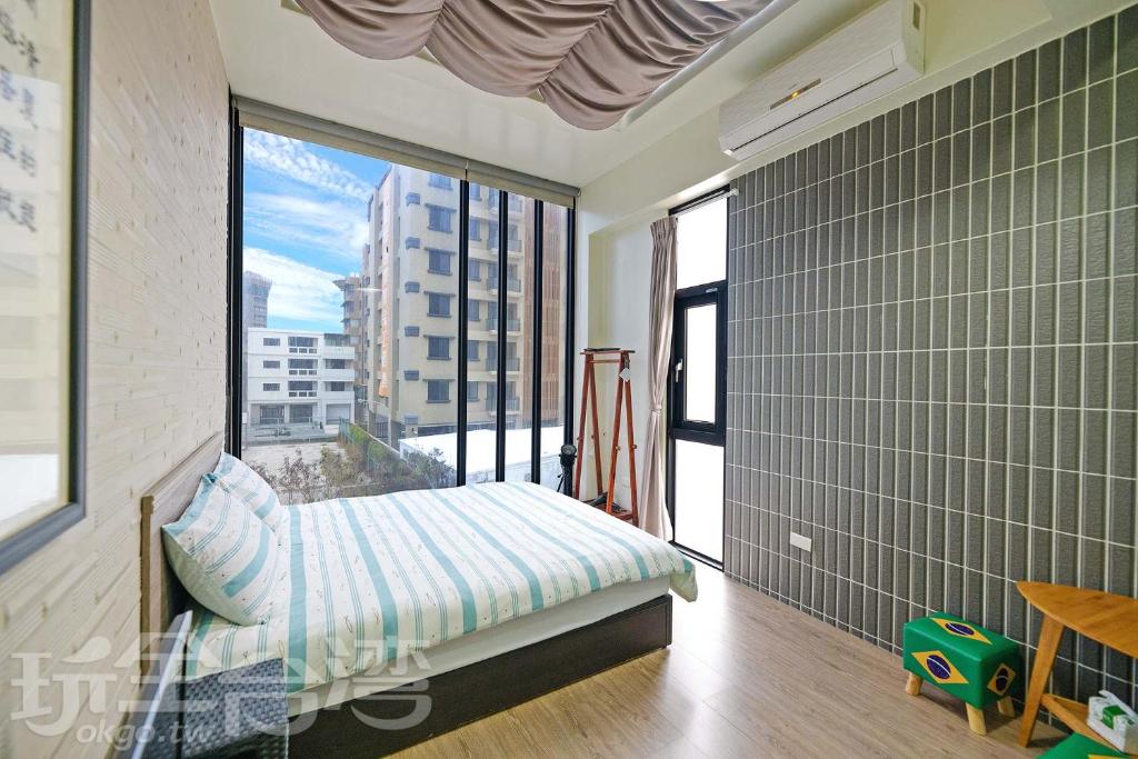 a bedroom with a bed and a large window at Penghu 123 V-Stone in Magong