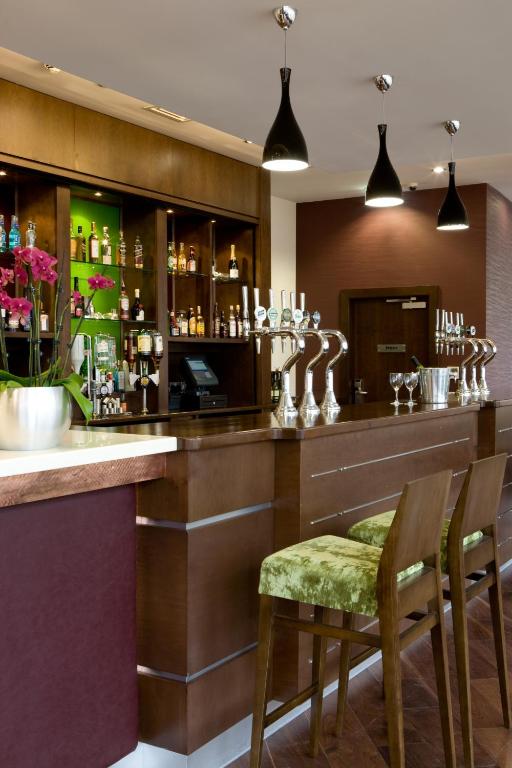 a bar in a hotel with two chairs and a counter at Leonardo Hotel Aberdeen in Aberdeen