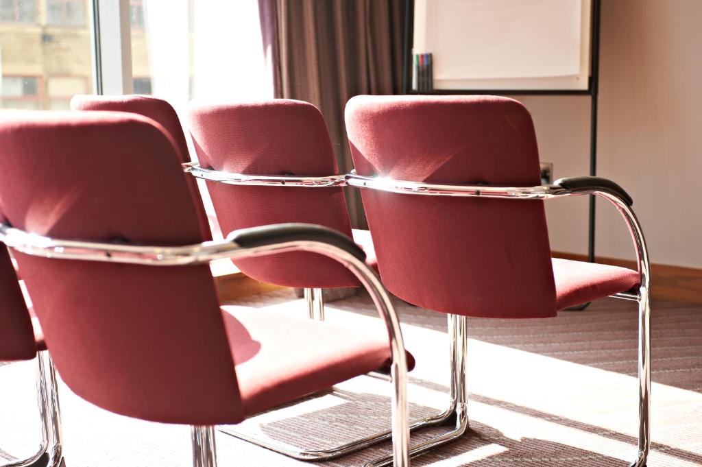 a row of red chairs in a room at Leonardo Hotel Aberdeen in Aberdeen