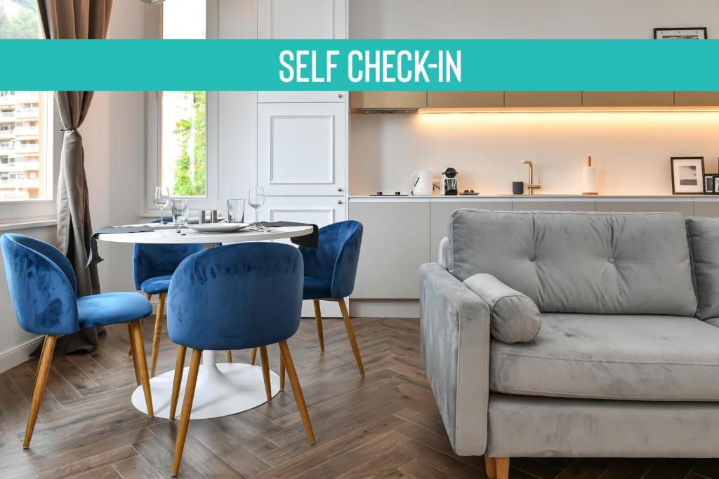 a living room with a couch and a table and chairs at Luxury Apartment next to Monte Carlo in Beausoleil