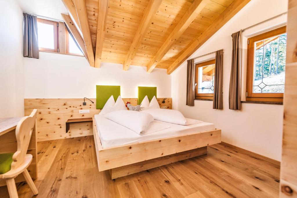 a bedroom with a bed and a desk at Untermathonhof - Guestpass included in Verano