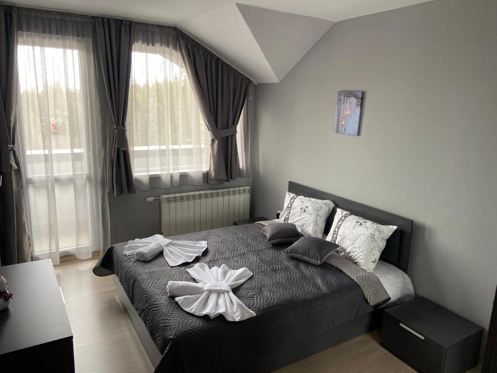 a bedroom with a bed with a bow on it at Ski Apartment Boyika Iglika 2 in Borovets