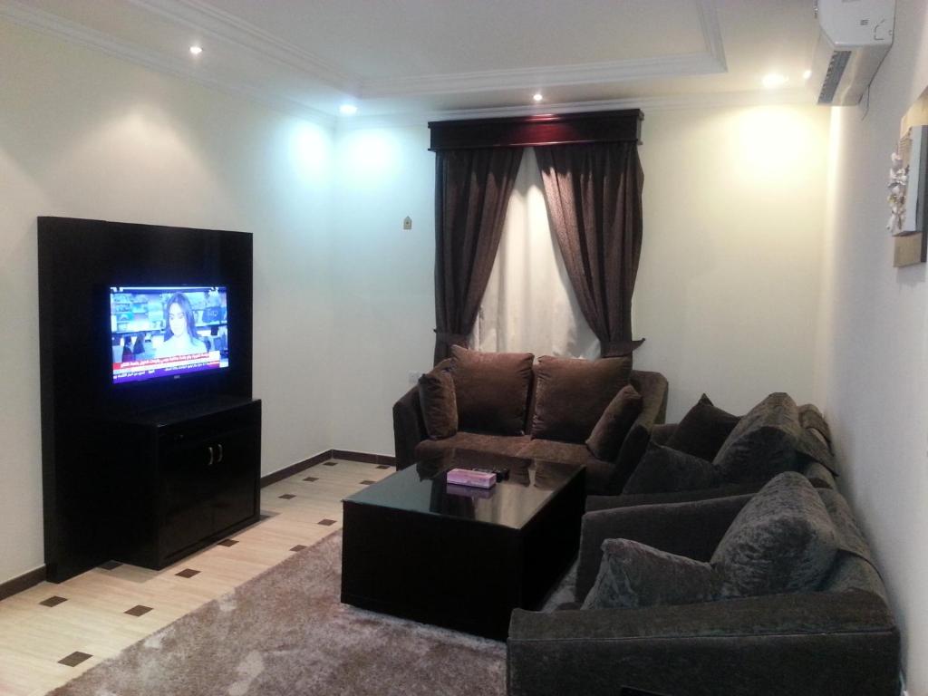 a living room with a couch and a television at Dorar Darea Hotel Apartments- Al Malqa 2 in Riyadh