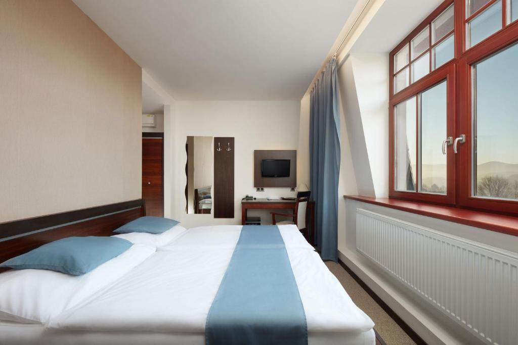 Postel nebo postele na pokoji v ubytování Hotel Slunný Dvůr
