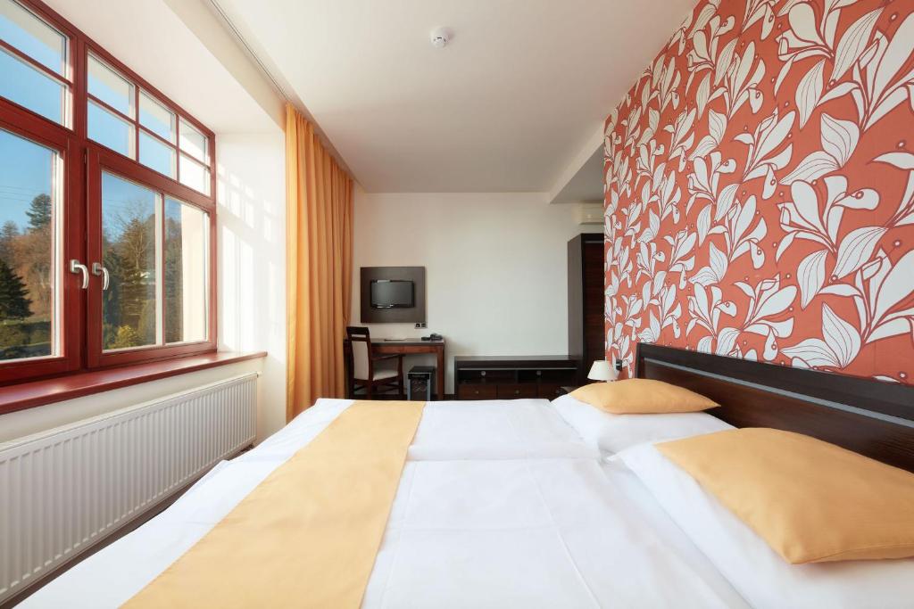 Postel nebo postele na pokoji v ubytování Hotel Slunný Dvůr