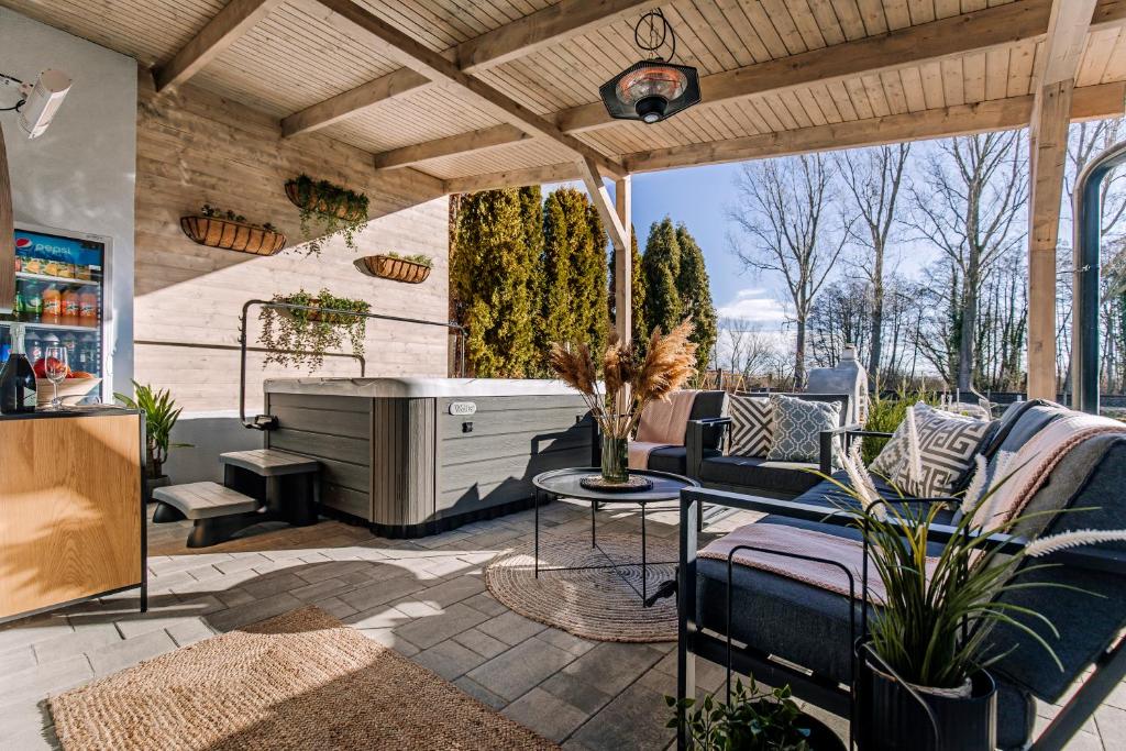 a patio with a couch and a table and chairs at Nádas Center Home Badacsony in Badacsonytomaj