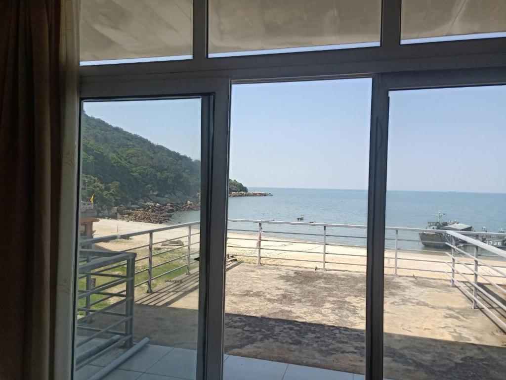 uma vista para o oceano a partir de uma janela em 馬港驛站 Oldharbor Hostel em Nangan