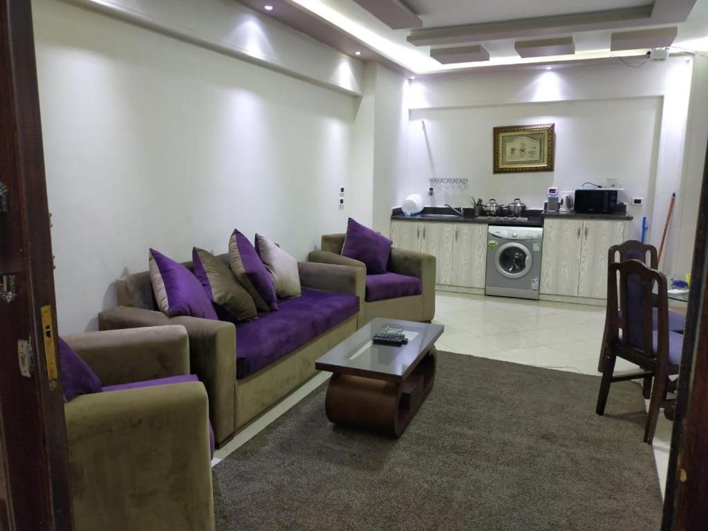 een woonkamer met paarse banken en een tafel bij SARAYA AWAD HEGAZI STREET- families only in Alexandrië