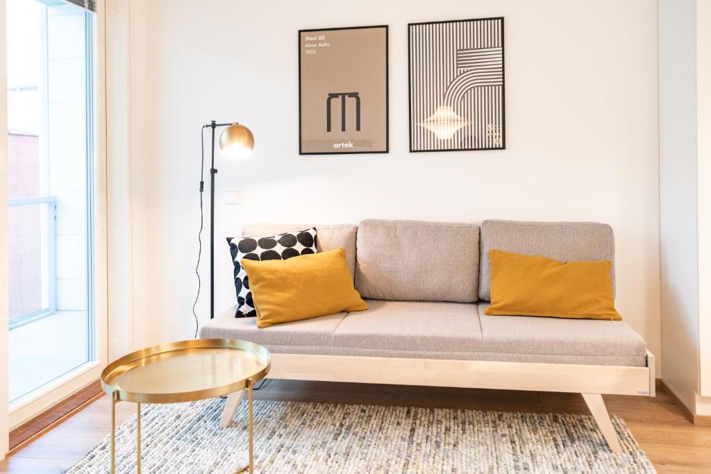 uma sala de estar com um sofá e uma mesa em Apartment City em Oulu