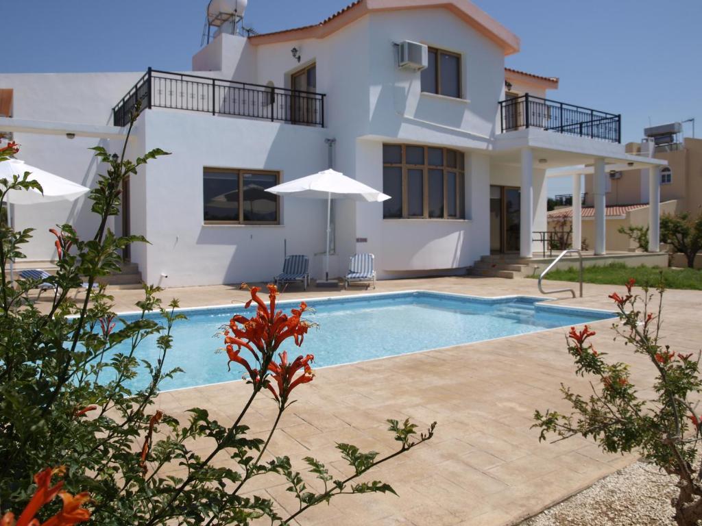 una villa con piscina frente a una casa en Mariandy Villa 2, en Bahía de Coral