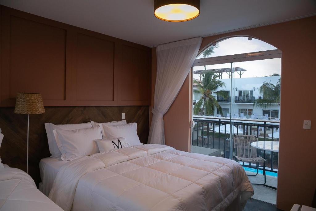 une chambre avec deux lits et un balcon avec vue dans l'établissement Mero Hotel Boutique, à Barra Grande