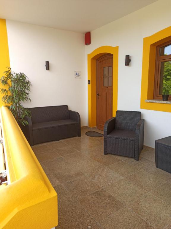 uma sala de estar com dois sofás e uma porta amarela em Porto D'Abrigo - Alojamento Local em Sardoal