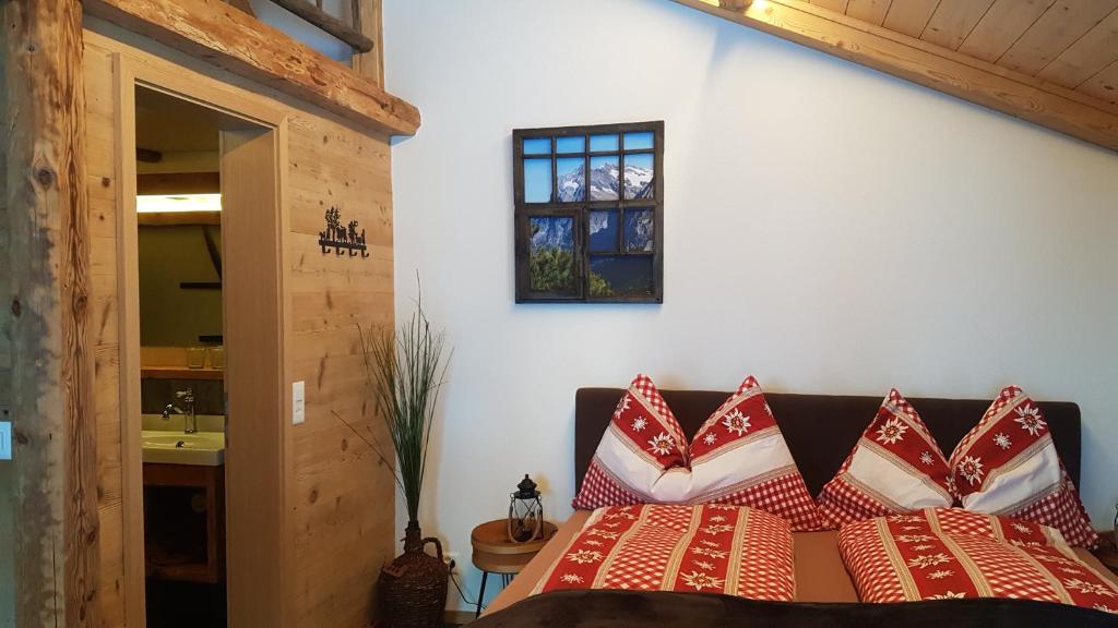 a bedroom with a bed with red and white pillows at Chalet bei der Arve in Grindelwald