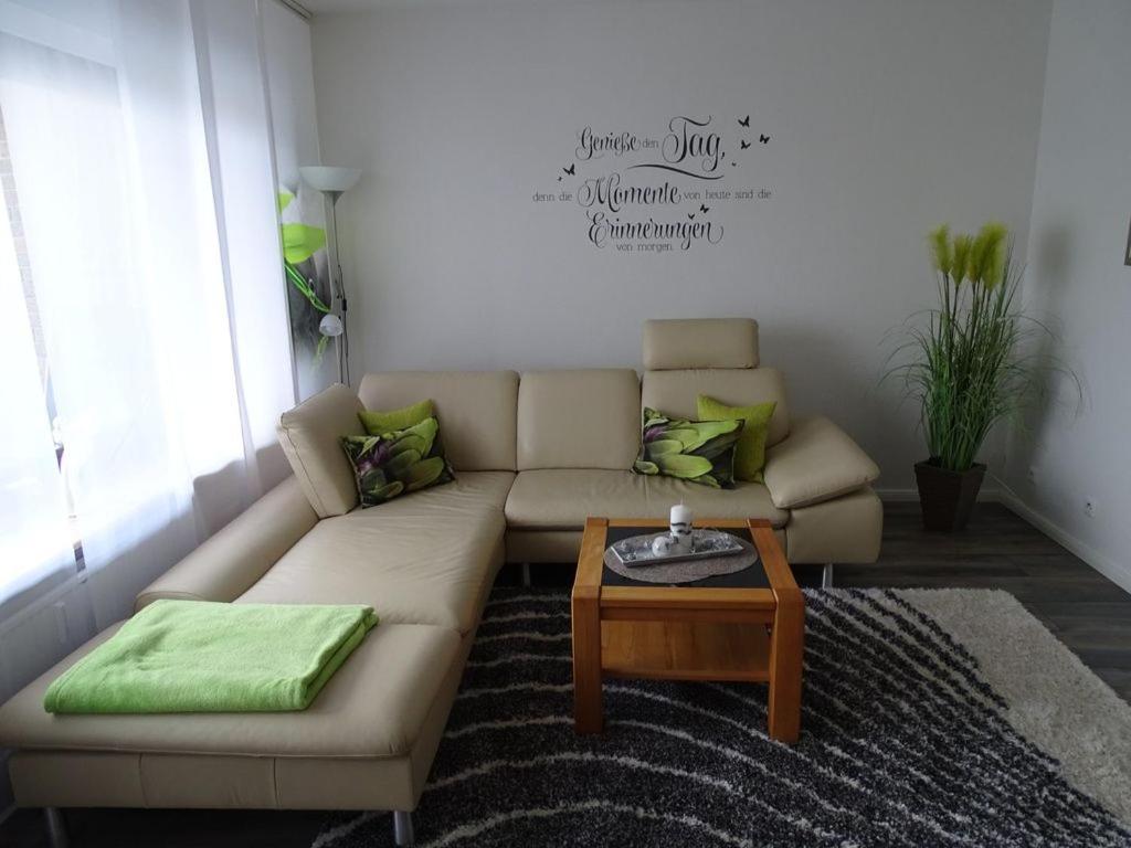 sala de estar con sofá y mesa de centro en Wunderschöne Ferienwohnung ´Mal seh´n`direkt am Nordseedeich, en Friedrichskoog-Spitz