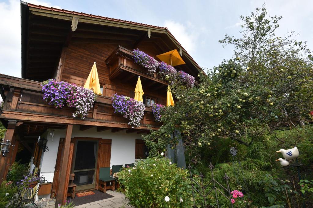 ein Haus mit Blumen auf dem Balkon in der Unterkunft Chiemsee-Ferienwohnungen in Traunstein