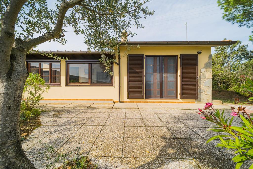 a yellow house with a tree in front of it at Cottage Casa Gina - Goelba in Capoliveri