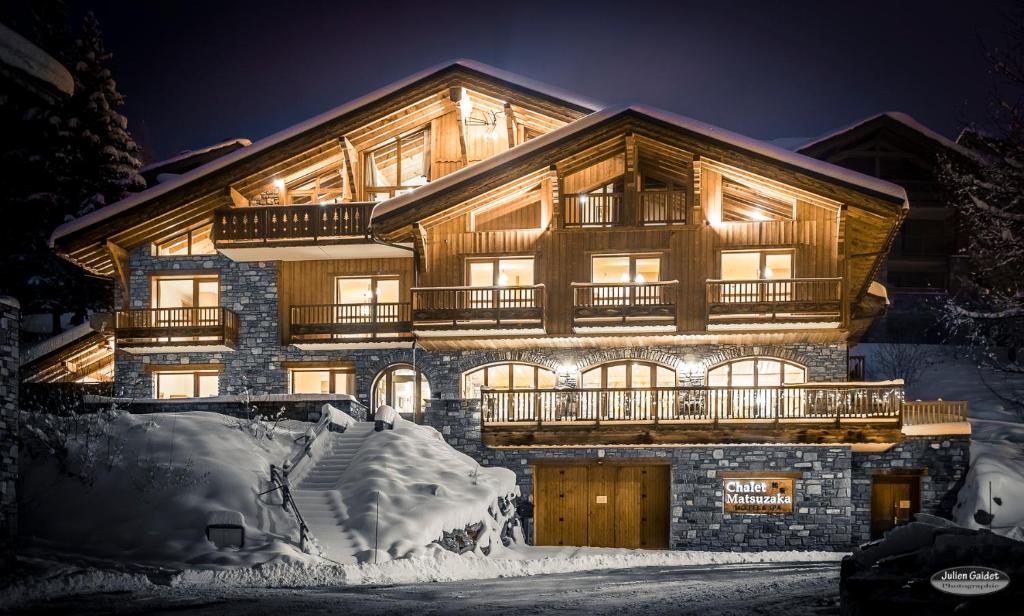 a large wooden building with snow in front of it at Chalet Matsuzaka - chambres d'hôtes de luxe in La Rosière