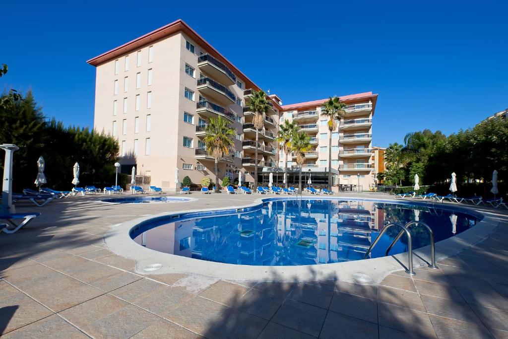 une grande piscine en face d'un bâtiment dans l'établissement Pineda Park, à La Pineda