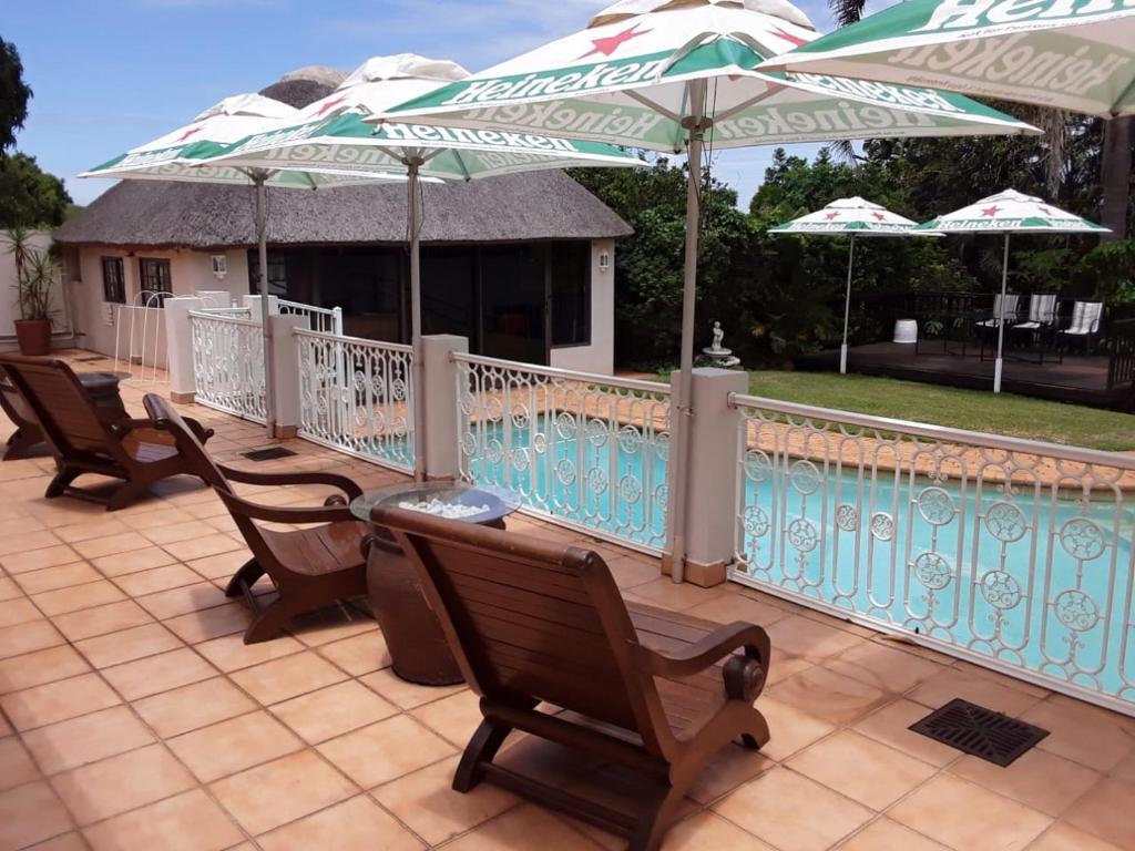 - une rangée de chaises et de parasols sur la terrasse dans l'établissement Mandalay Bed & Breakfast and Conference Centre, à Durban