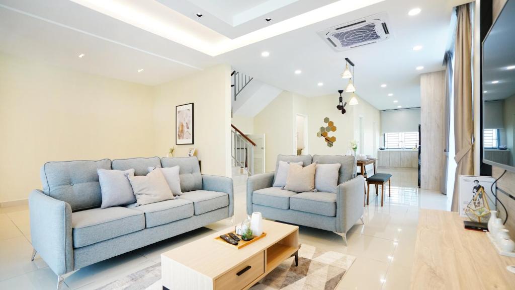 uma sala de estar com dois sofás azuis e uma mesa em Desaru Exclusive Elegant theme by Joyfully 2M8 em Desaru