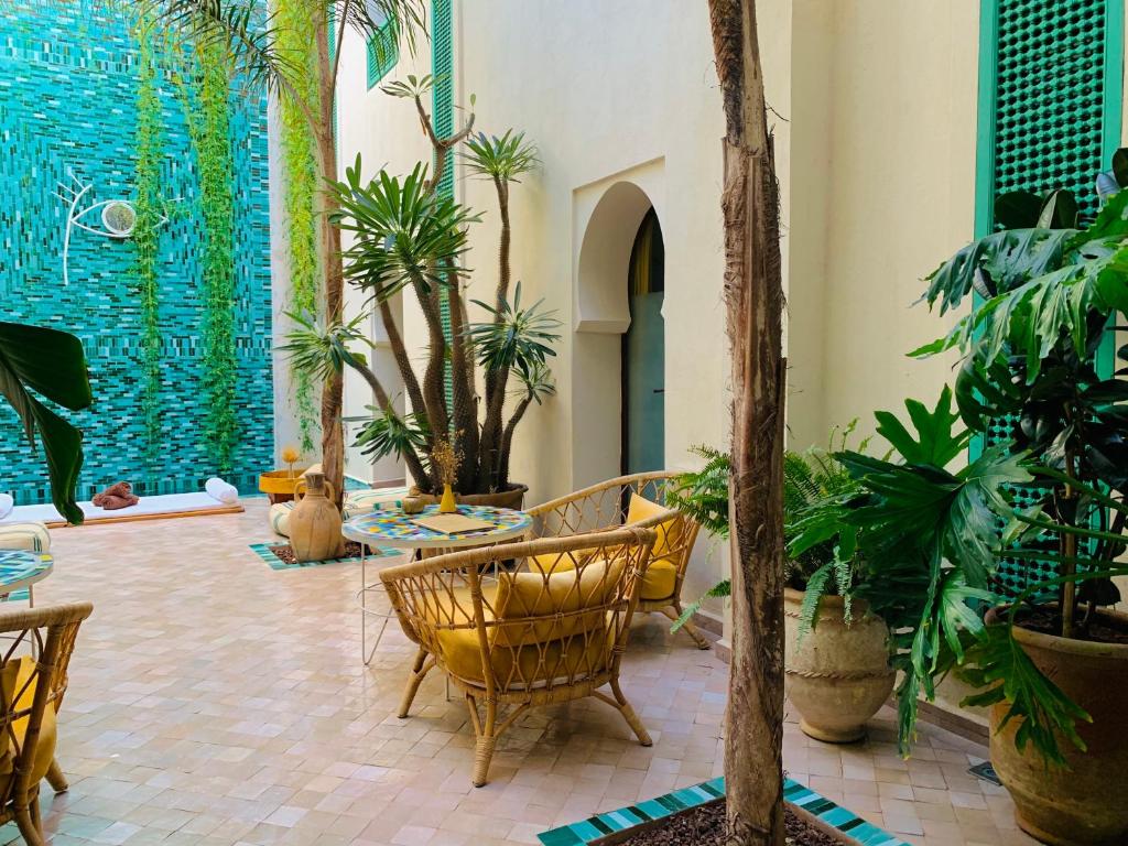 una hall con un mucchio di piante e sedie di Riad Alia a Marrakech