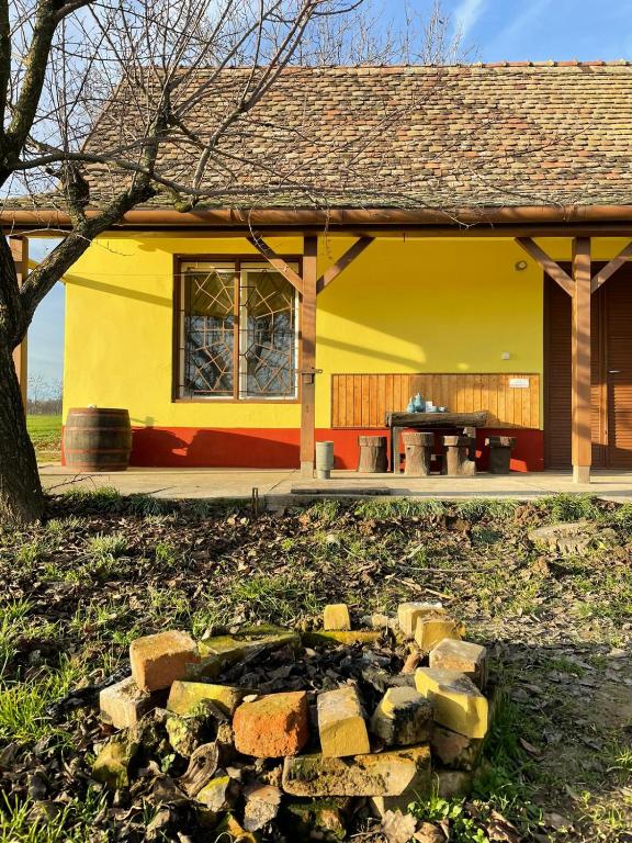 żółty dom z kupą cegieł przed nim w obiekcie Het Hongaarse Wijnhuis w mieście Mohacz