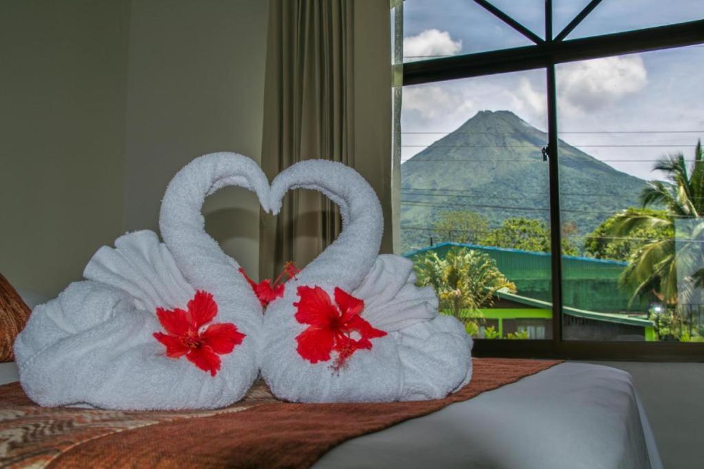 dos toallas con forma de cisnes sentadas encima de una cama en Hotel Vista del Cerro, en Fortuna