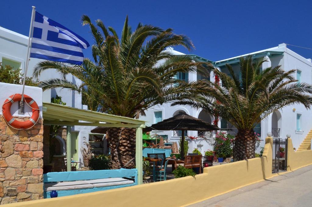 a hotel with palm trees in front of a building at Villa Ostria in Koufonisia