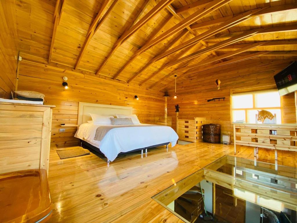 sypialnia z łóżkiem w drewnianym domku w obiekcie Mágica y Romantica Cabaña, 10 min Centro w mieście Chiquinquirá