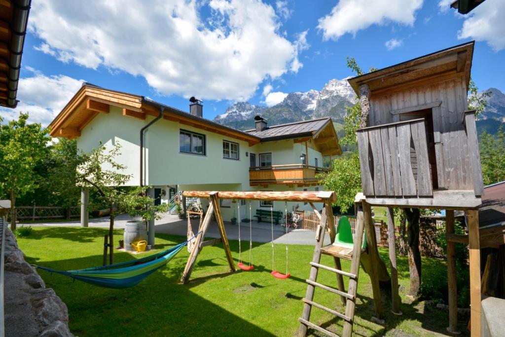 a backyard with a swing set and a house at Ferienwohnung Pletzenauer in Leogang
