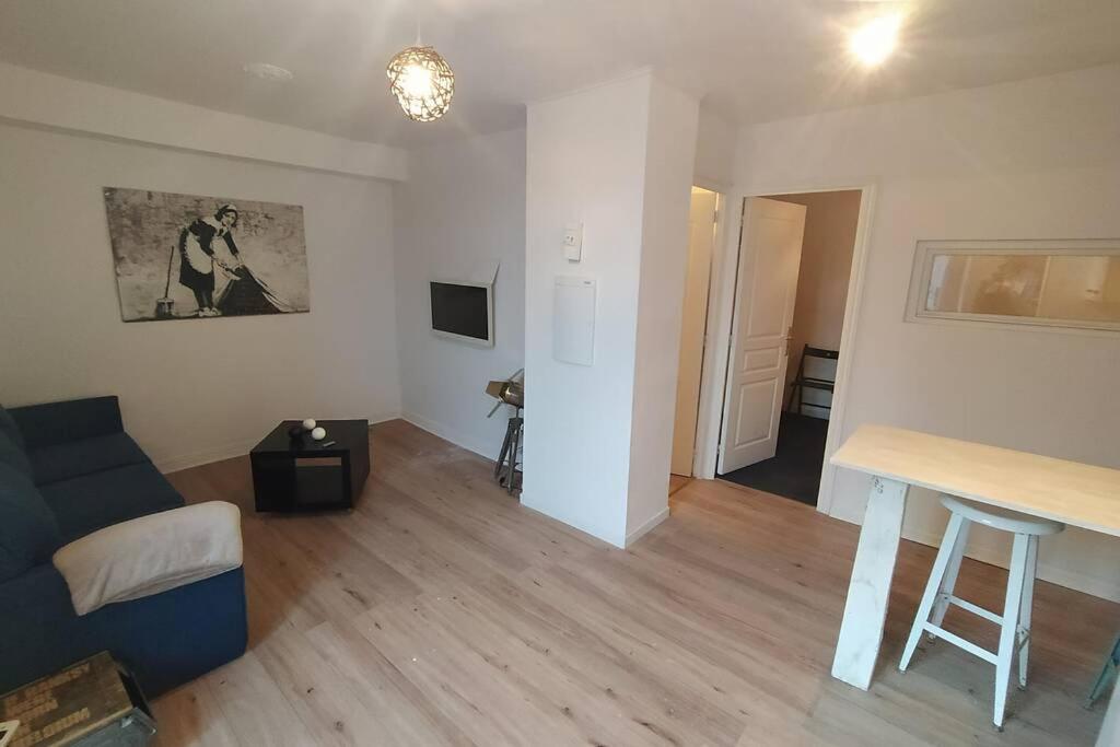 sala de estar con sofá y mesa en Appartement T2 cosy et chaleureux - 40mn de Rennes, en Plumaugat