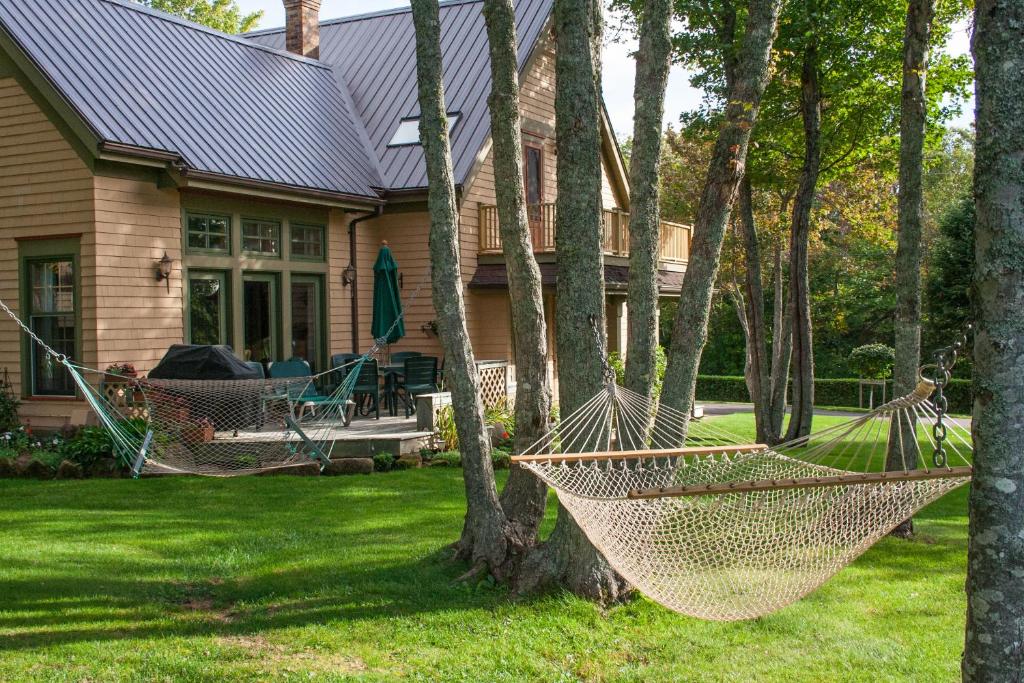 a house with two hammocks in the yard at Cavendish Maples Cottages in Cavendish