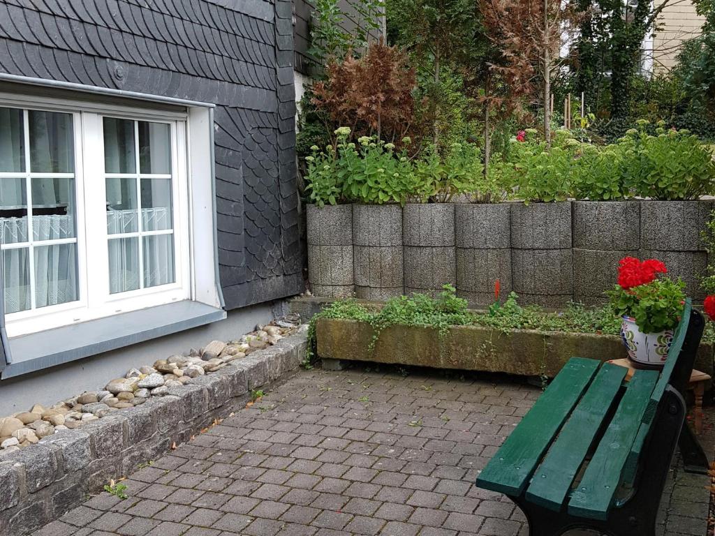 a green bench sitting next to a building with a window at Ferienwohnung Alwine Schulte in Brilon