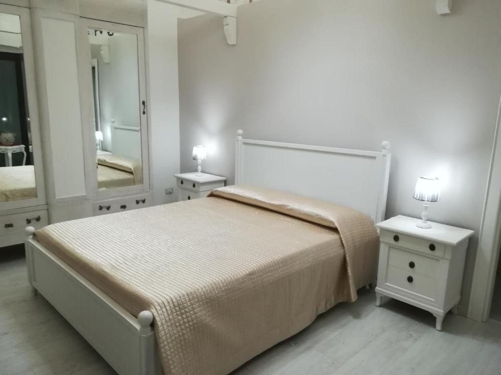 - une chambre avec un lit, 2 tables de chevet et un miroir dans l'établissement B&B Il RE, à Castellaneta