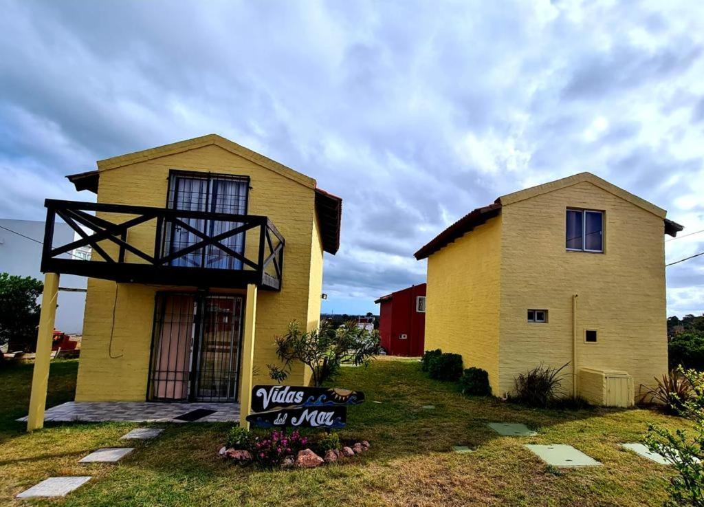 uma casa amarela com um telhado de gambrel em Complejo Vidas del Mar em Punta Del Diablo