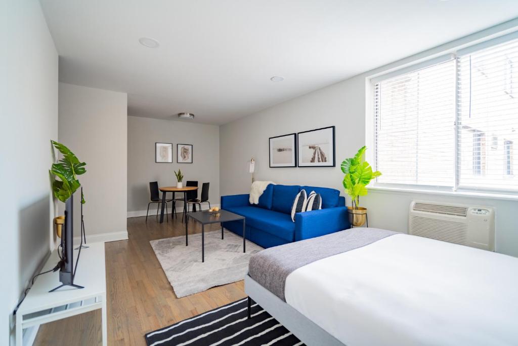 um quarto com uma cama e um sofá azul em Comfy and Complete Studio Apt near Boystown - Oakdale 317 rep em Chicago