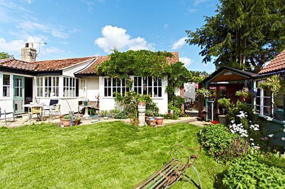 een wit huis met een tuin met een tuin bij Wayside B&B in Norwich