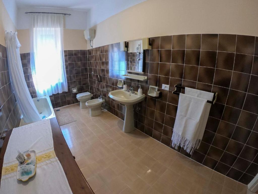 W łazience znajduje się umywalka, toaleta i umywalka. w obiekcie Casa A&M w mieście Onifai