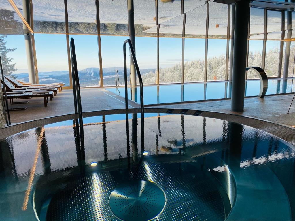 a hot tub in a building with a view of the mountains at Hotel Tetřeví Boudy in Pec pod Sněžkou