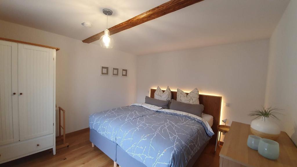 a bedroom with a bed with a blue comforter at Zur alten Bäckerei - Finsterbergen in Friedrichroda