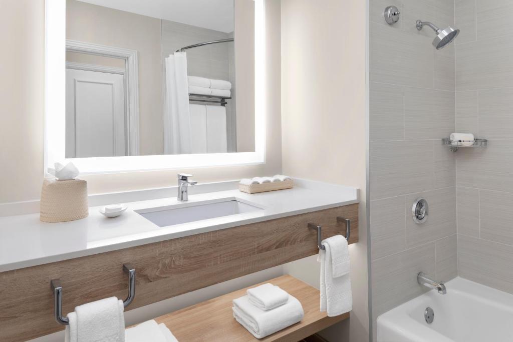 Un baño con lavabo, espejo y bañera. en The Royal at Atlantis, en Nassau