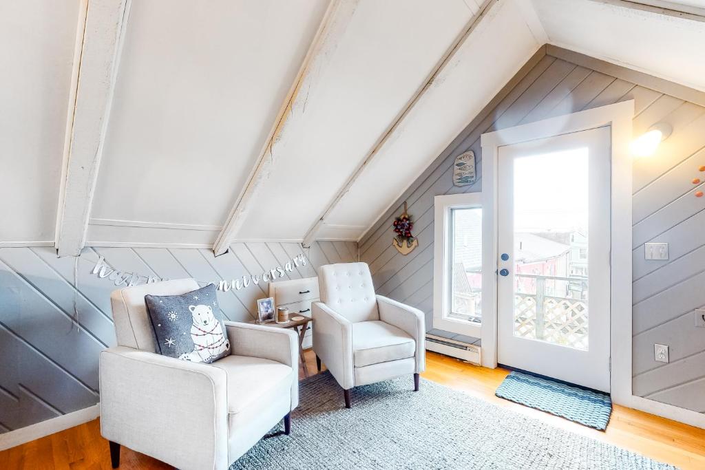 a attic room with two chairs and a window at Monument View in Provincetown