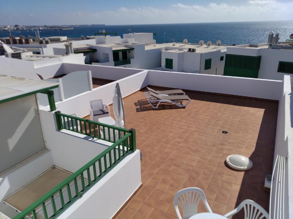 balkon z krzesłami i widokiem na ocean w obiekcie Apartamentos Casa Cipri w mieście Playa Blanca