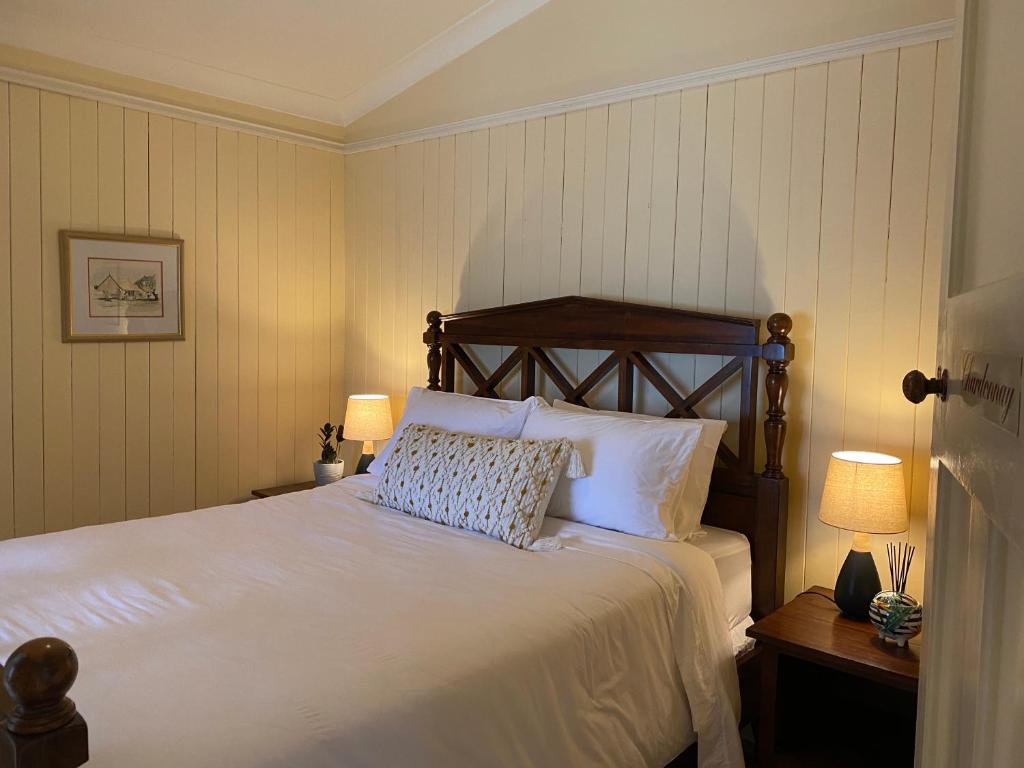 um quarto com uma grande cama branca e 2 candeeiros em Big Fella Wines & Accommodation em Stanthorpe