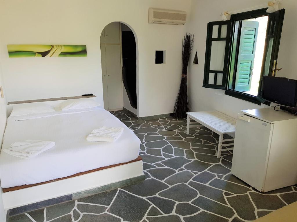 a bedroom with two beds and a flat screen tv at Andromeda in Exámbela