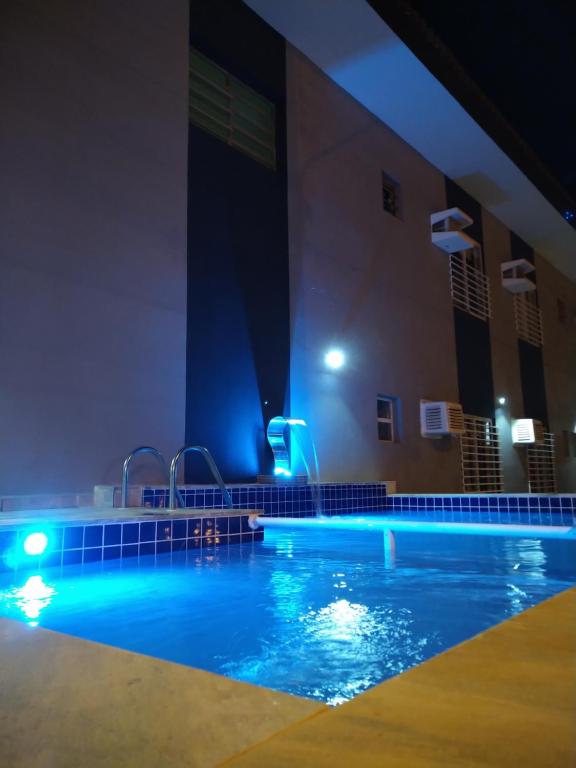 a swimming pool at night with blue lights at Pousada Maré Enseada in Guarujá