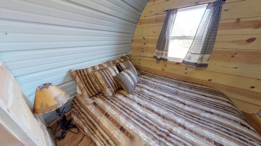 1 dormitorio con 1 cama en una cabaña de madera en Western Covered Wagon, en Monticello