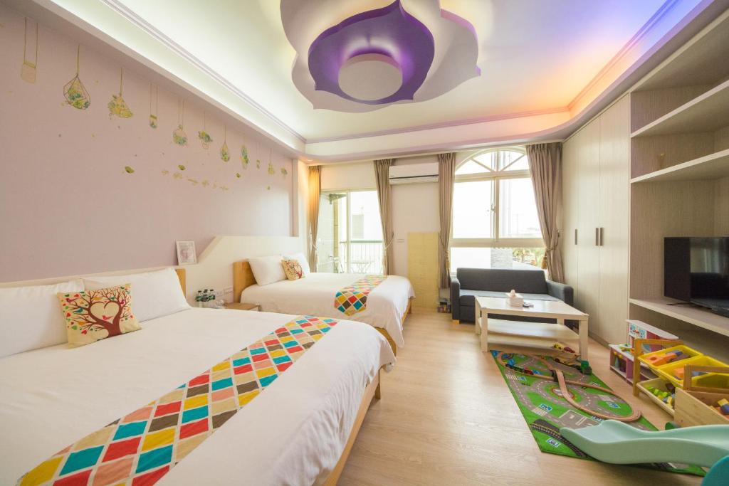 um quarto de hotel com duas camas e uma televisão em Childlike B&B em Wujie